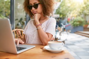 Woman at sidewalk cafe reading emails